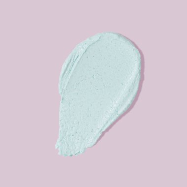 Pembe arka planda mavi maske lekesi. Kozmetik cilt ürünü dokusu. Yüz kremi, vücut losyonu, maske izi.