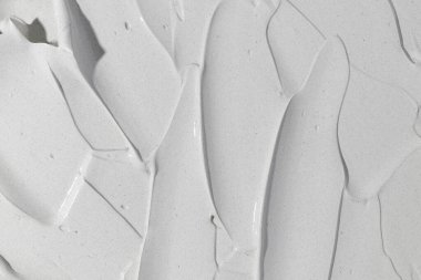 Güzellik kremi dokusu. Gri kozmetik maske arka planı. Kremalı cilt ürünleri yakın çekim