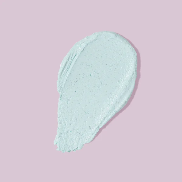 Blue beauty mask smear smudge on pink background. Cosmetic skincare product texture. Face cream, body lotion, mask swipe swatch