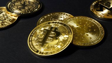 Siyah arka planda altın renkli bitcoin paralar. İnternet ve döviz piyasasında kripto para ticareti