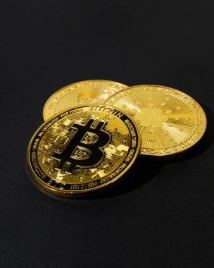 Siyah arka planda altın renkli bitcoin paralar. İnternet ve döviz piyasasında kripto para ticareti