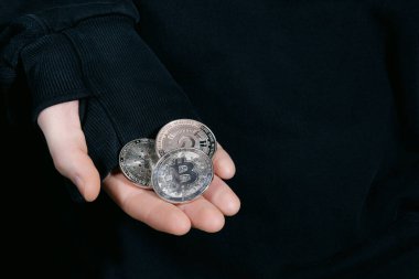 Yatırımcı adam şifreli paralar ve Amerikan banknotları gösteriyor. Yakın plan fotoğraf. Mesaj için yer var. Sanal kripto para birimi ve gelecekteki para kavramı.