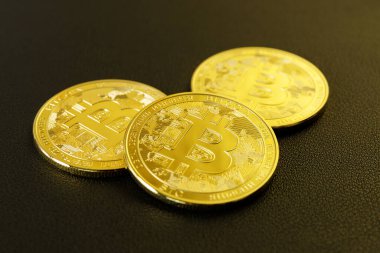 Siyah arka planda altın renkli bitcoin paralar. İnternet ve döviz piyasasında kripto para ticareti