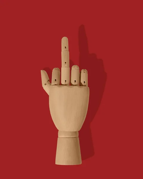 Wooden hand show middle finger on red background
