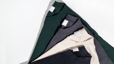 Boş etiketli çeşitli renklerde düz tişörtler. Beyaz arka planda izole edilmiş tişörtler. Logo için yer var. Model