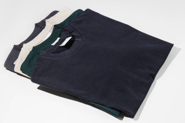 Boş etiketli çeşitli renklerde düz tişörtler. Beyaz arka planda izole edilmiş tişörtler. Logo için yer var. Model