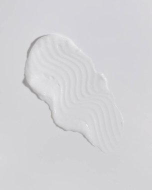 White beauty cream smear smudge on white background. Cosmetic skincare product texture. Face cream, body lotion swipe swatch 