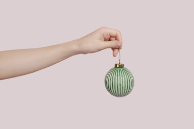 Noel ağacı süslemesi tutan pembe bir arka plan. Noel konsepti, kopyalama alanı.