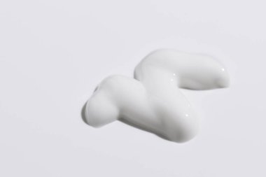 White beauty cream smear smudge on white background. Cosmetic skincare product texture. Face cream, body lotion swipe swatch