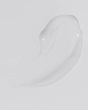 White beauty cream smear smudge on white background. Cosmetic skincare product texture. Face cream, body lotion swipe swatch