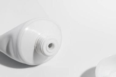 Açık beyaz kapaklı boş tüp, diş macunu, krem, jöle ya da şampuan için model şablonu, beyaz arka planda boş paket