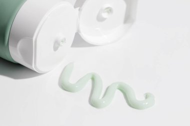 Beyaz arka planda güzellik kremi olan yeşil plastik kozmetik tüp. Model