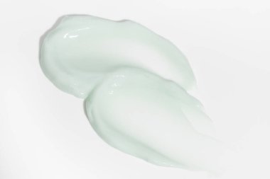 Beyaz arka planda yeşil güzellik kremi lekesi. Kozmetik cilt ürünü dokusu. Yüz kremi, vücut losyonu sürgüsü.