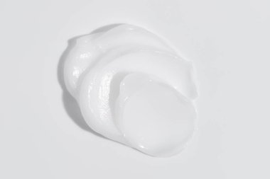White beauty cream smear smudge on white background. Cosmetic skincare product texture. Face cream, body lotion swipe swatch
