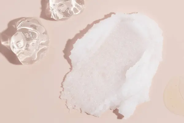 Λευκή Ζάχαρη Scrub Και Διαφανές Υγρό Τζελ Ροζ Φόντο Καλλυντικά Εικόνα Αρχείου