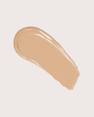 Makyaj vakfı, bej kapatıcı bej arka planda leke lekesi. BB CC krem dokusu