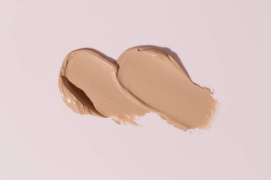 Makeup foundation, beige concealer swatch smudge smear on pink background. BB CC cream texture