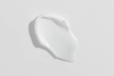 White beauty cream smear smudge on white background. Cosmetic skincare product texture. Face cream, body lotion swipe swatch