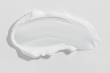 White beauty cream smear smudge on white background. Cosmetic skincare product texture. Face cream, body lotion swipe swatch