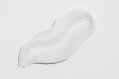 White beauty cream smear smudge on white background. Cosmetic skincare product texture. Face cream, body lotion swipe swatch