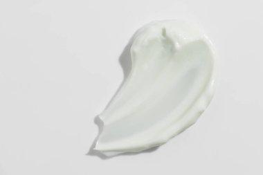 Beyaz arka planda yeşil güzellik kremi lekesi. Kozmetik cilt ürünü dokusu. Yüz kremi, vücut losyonu sürgüsü.