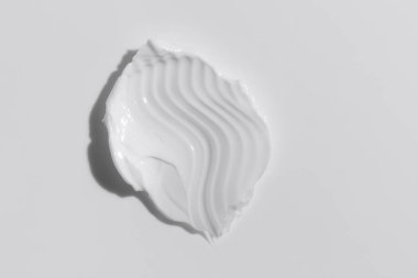 White beauty cream smear smudge on white background. Cosmetic skincare product texture. Face cream, body lotion swipe swatch