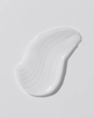 White beauty cream smear smudge on white background. Cosmetic skincare product texture. Face cream, body lotion swipe swatch