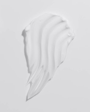 White beauty cream smear smudge on white background. Cosmetic skincare product texture. Face cream, body lotion swipe swatch