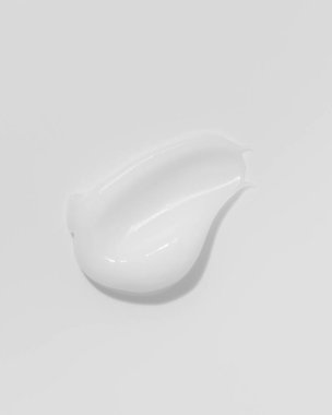 White beauty cream smear smudge on white background. Cosmetic skincare product texture. Face cream, body lotion swipe swatch