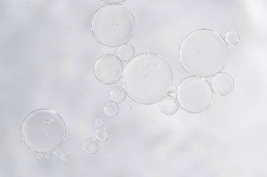 Makro yakın plan temiz kozmetik serumu ya da görünür hava kabarcıkları olan özü. Güzellik markası, kozmetik reklamları, cilt malzemesi tasarımı veya en az ürün sunumu için ideal.