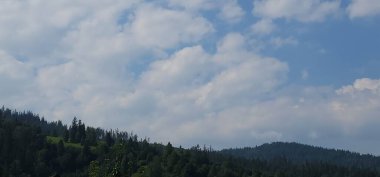 Dağları ve mavi gökyüzü olan güzel bir manzara.