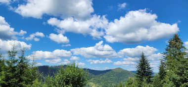 Dağları ve mavi gökyüzü olan güzel bir manzara.