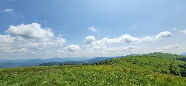 Dağları ve mavi gökyüzü olan güzel bir manzara.