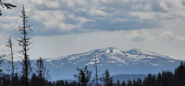 Dağlarda, mavi gökyüzünün altında güzel bir sıradağ görüntüsü.