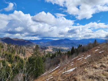 Dağları ve mavi gökyüzü olan güzel bir manzara.