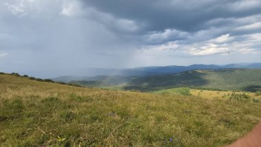 Sırt çantalı bir adam dağın tepesinde..