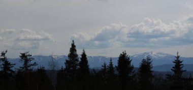 Bulutlu bir gökyüzünün tepesindeki dağdan manzara
