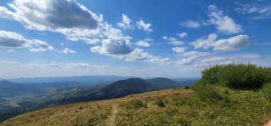 Dağları ve mavi gökyüzü olan güzel bir manzara.