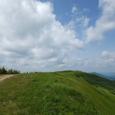 Dağları ve mavi gökyüzü olan güzel bir manzara.