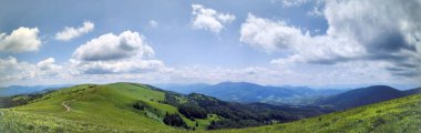 yeşil dağların panoramik manzarası ve mavi bulutlu gökyüzü