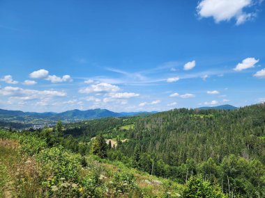 Dağları ve mavi gökyüzü olan güzel bir manzara.
