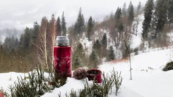 red cup of tea in winter forest