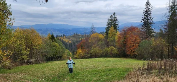 young woman with backpack hiking in autumn forest