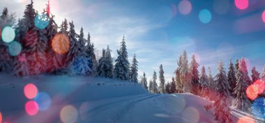 Önplanda parlayan renkli bokeh neşeli bir hava yaratıyor, sıcaklık ve kutlama atmosferi yaratıyor. Arka planda bir kış manzarası mevsimlik cazibenin büyülü bir karışımıyla Noel ve Yeni Yıl 'ın özünü yakalıyor..