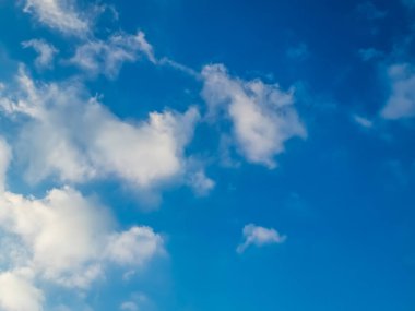 Mavi gökyüzünde kabarık beyaz kümülüs bulutları yaklaşır