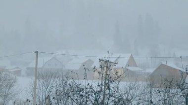 Kışın karlı bir dağ köyü manzarası.