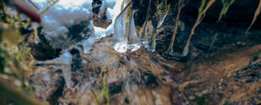 Buz saçakları ve karlı donmuş dağ akıntısı