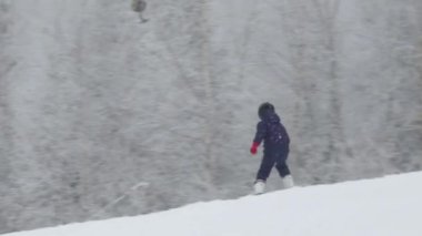 Kışın kar altında bir adam. Tepede kayak yapmak.