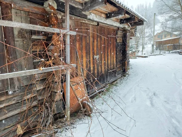 wooden fence covered with snow in winter. old wooden fence with a wooden roof
