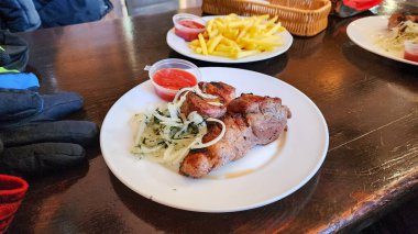 Ahşap bir masada lezzetli eti olan bir tabak.